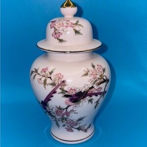 Hand-painted pink porcelain ginger jar with a floral and bird motif.